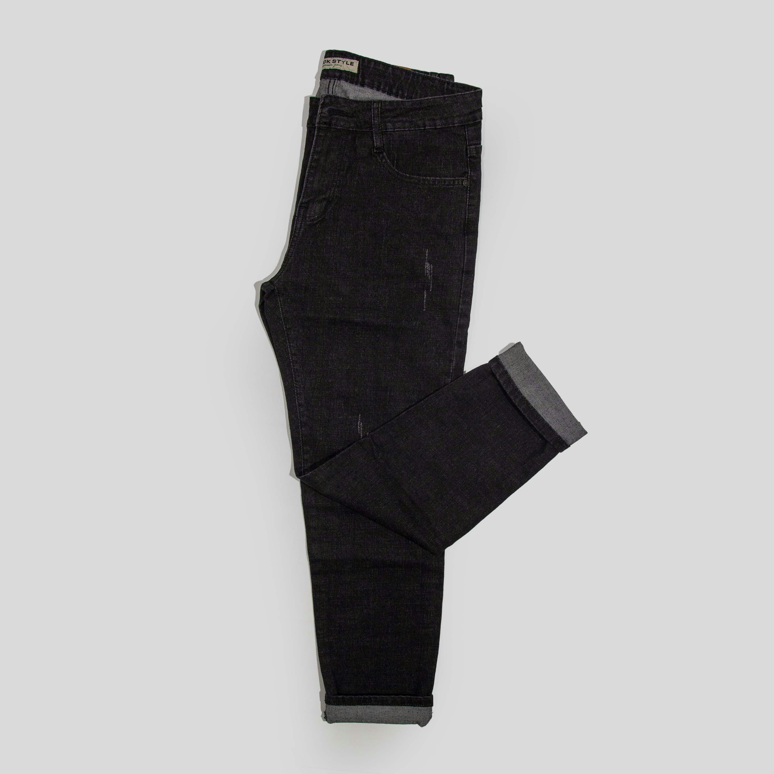 Black jeans folded on a light gray background